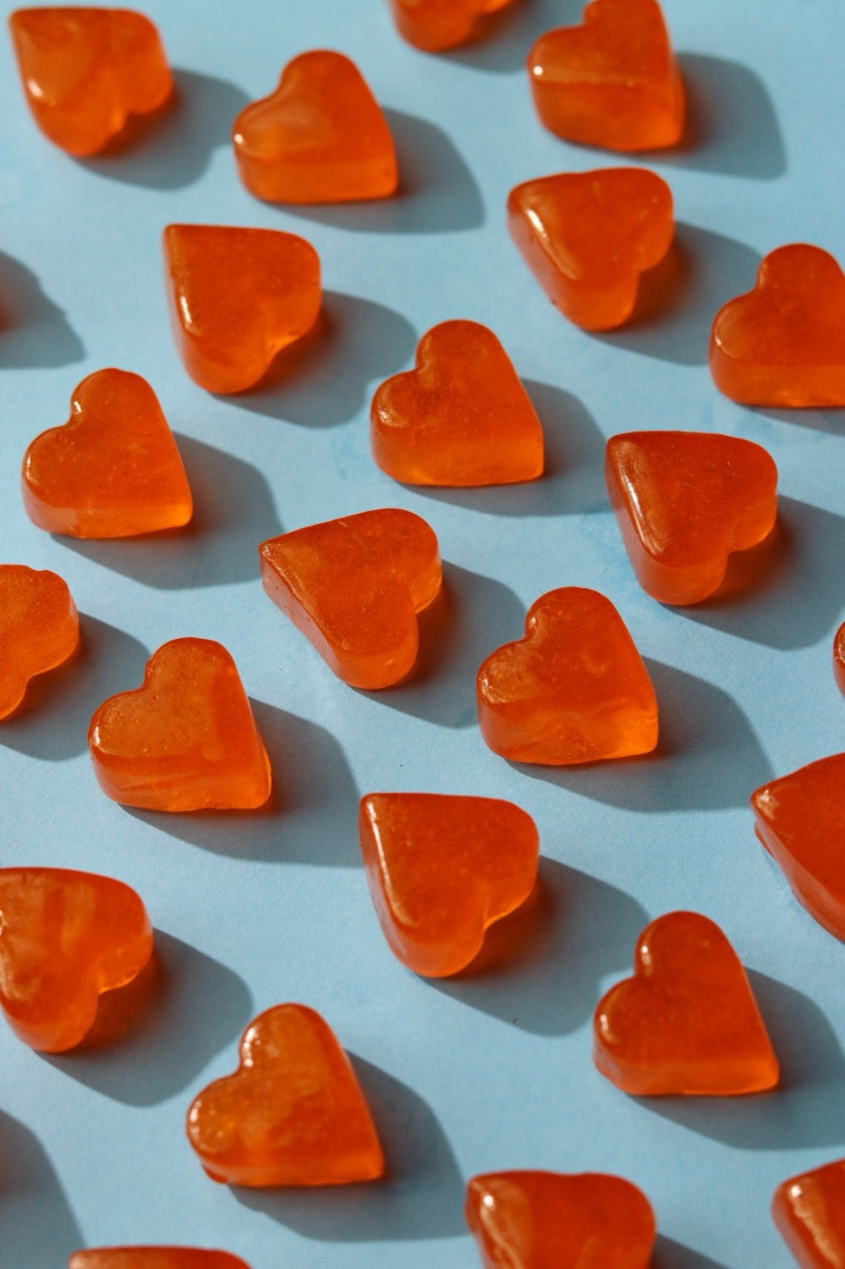 Heart-shaped gummies on blue
